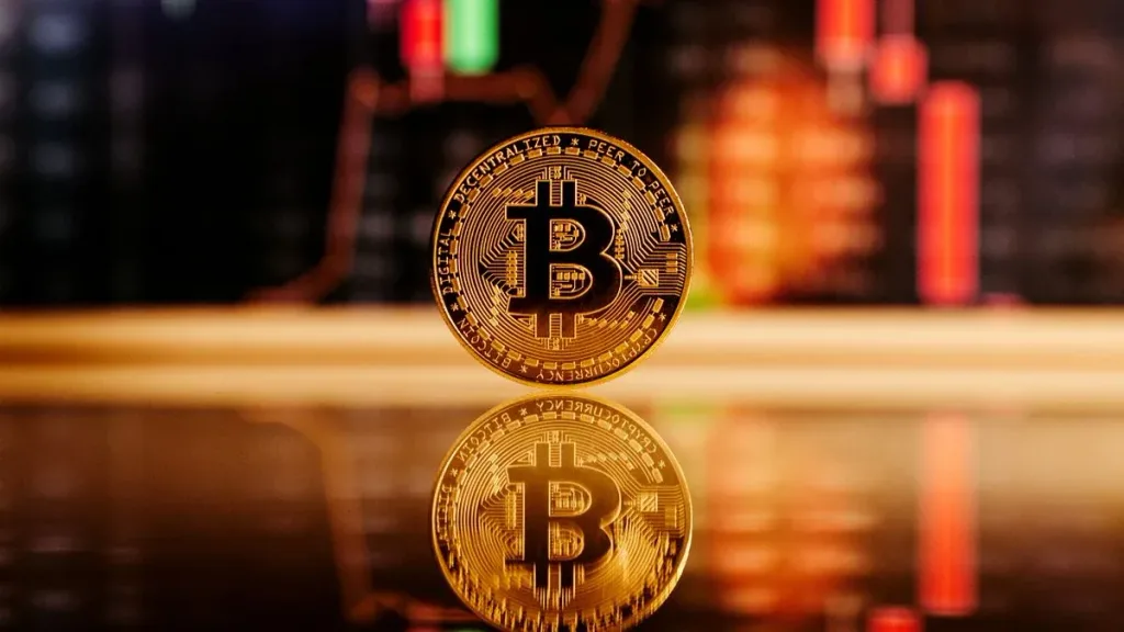Bitcoin coin in front of a cryptocurrency market chart