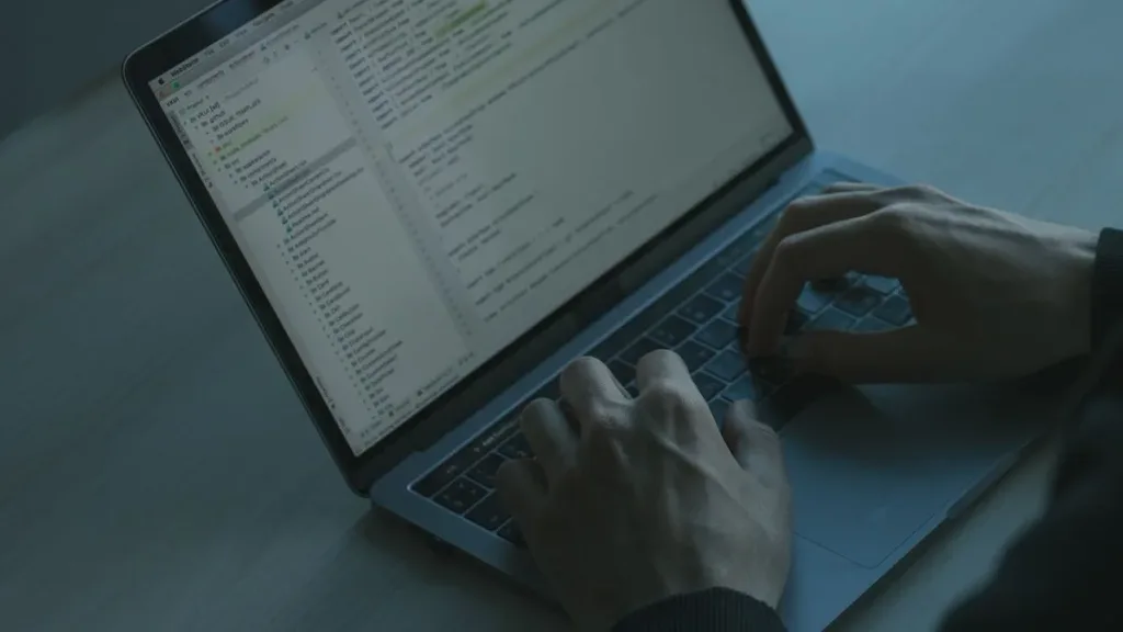 Hands typing on a laptop keyboard during cybersecurity work