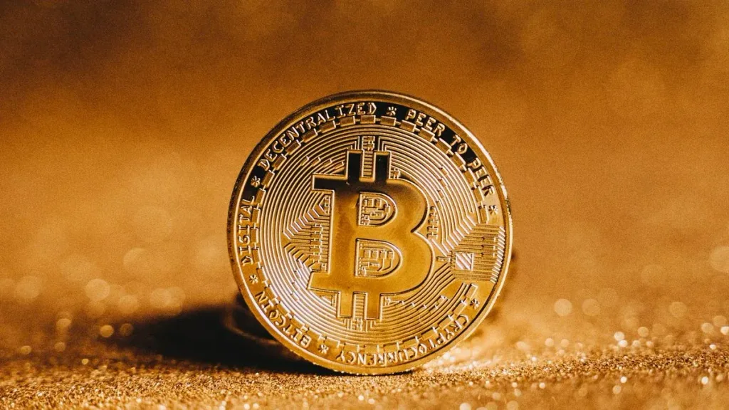 Close-up of a golden Bitcoin coin on a sparkling background