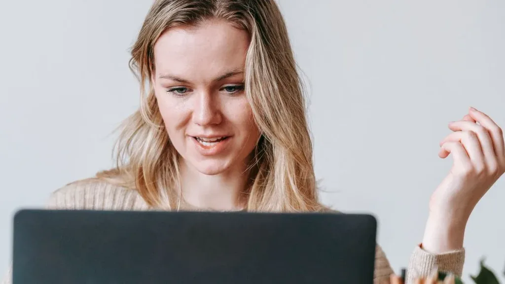 Focused freelancer working on a laptop at a bright home desk